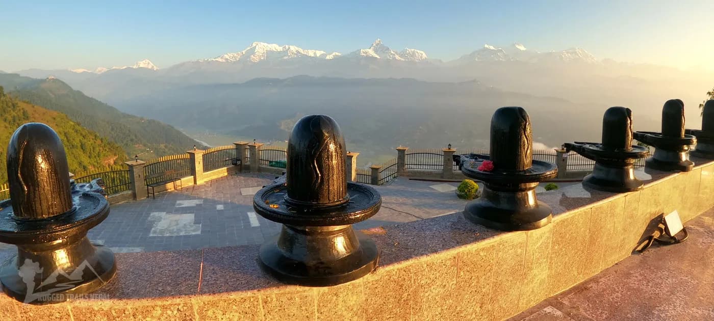 Black Shiva Lingam stone statues on outdoor temple terrace overlooking Annapurna mountain range in Pokhara