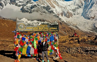 trekker standing at abc sign at the base camp