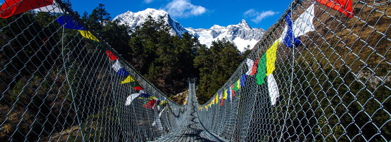 bridge on the manaslu circuit trek with prayer flags